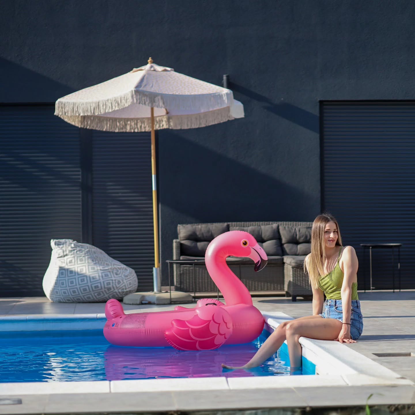 Gošća uz bazen s velikim flamingom na vodi